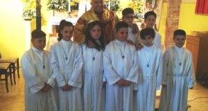 Il parroco e gli otto bambini che hanno ricevuto la Prima Comunione
