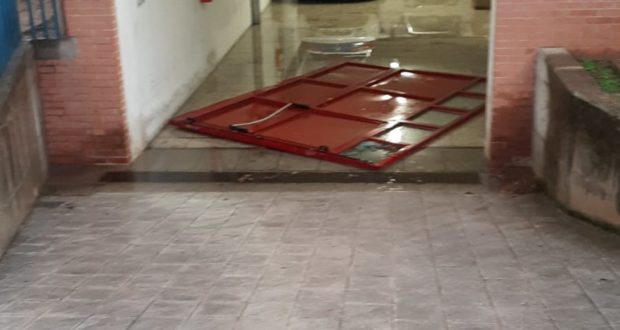 La porta divelta dall'acqua nel garage della Polizia locale