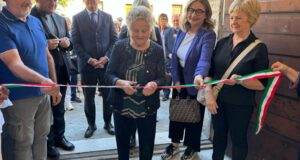 La signora Valenti taglia il nastro per l'inaugurazione dell'emporio diocesano solidale